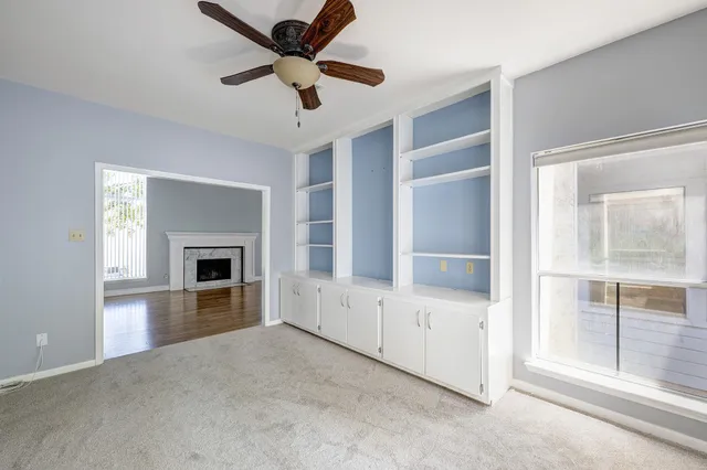 a view of an empty room with a fireplace and a window