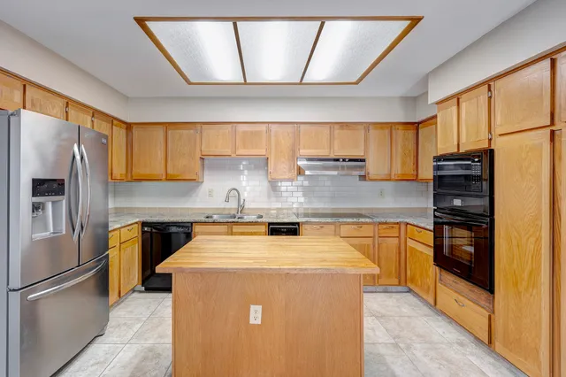 a kitchen with stainless steel appliances a refrigerator sink and cabinets