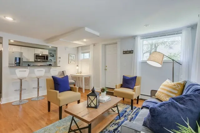 a living room with furniture and a dining table with kitchen view