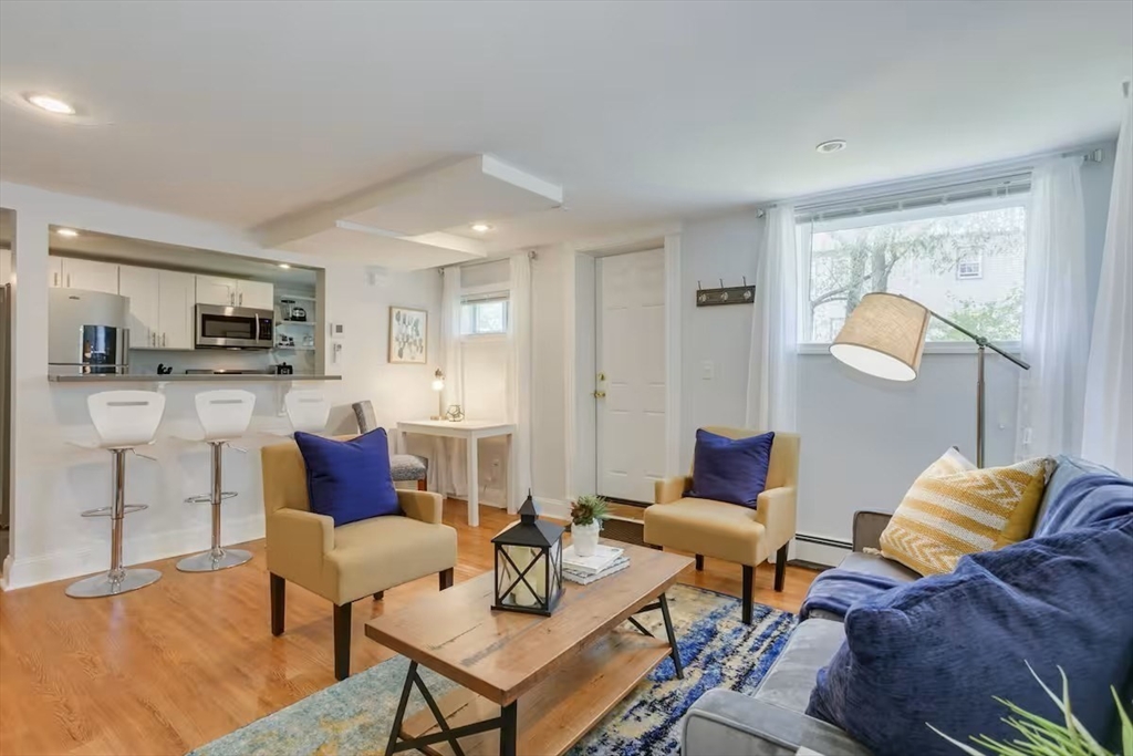 a living room with furniture and a dining table with kitchen view