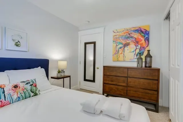 a bedroom with a bed and painting on the wall