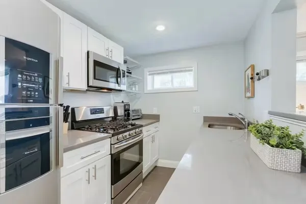 a kitchen with stainless steel appliances white cabinets and stove