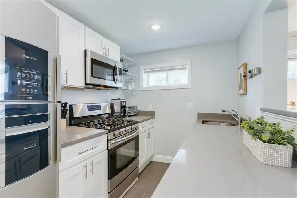 134 Newbury Avenue, Unit 1A Quincy, MA 02171 - Photo 4 of 13 a kitchen with stainless steel appliances white cabinets and stove
