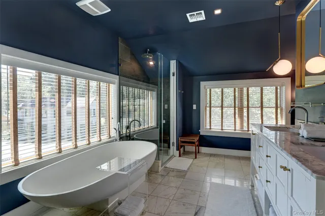 a spacious bathroom with a granite countertop tub sink and large window