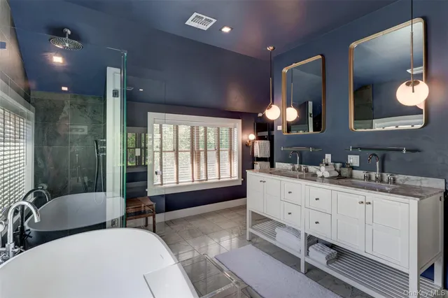 a spacious bathroom with double vanity a window and a mirror