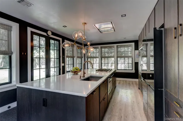 a dining hall with stainless steel appliances granite countertop a sink and a large window