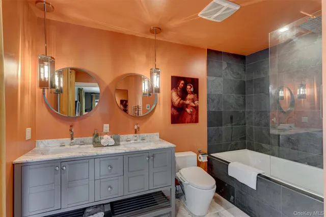 a bathroom with a double vanity sink toilet mirror and shower
