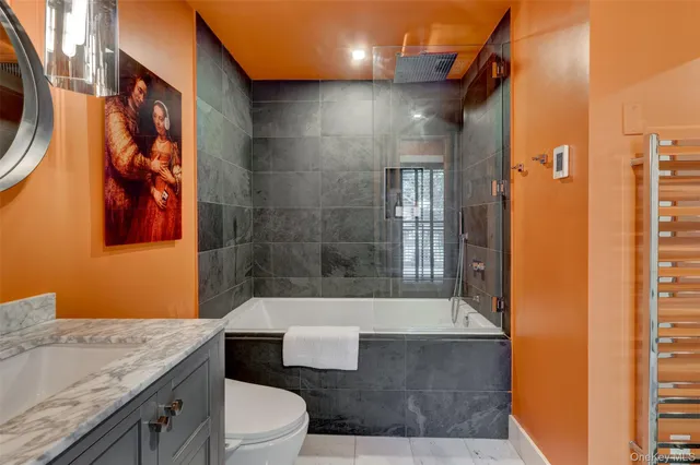 a bathroom with a granite countertop bathtub sink and toilet