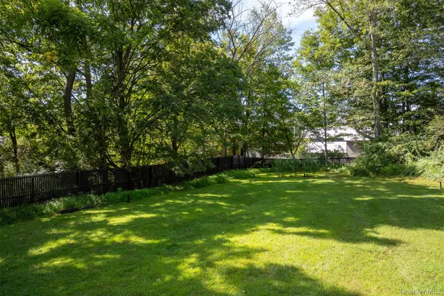 a view of green field with trees in the background