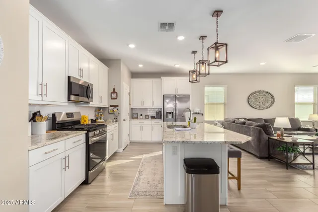 a living room with lots of furniture and view of kitchen