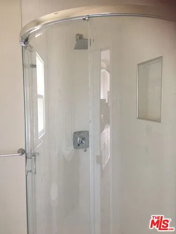 a bathroom with a shower and a glass door