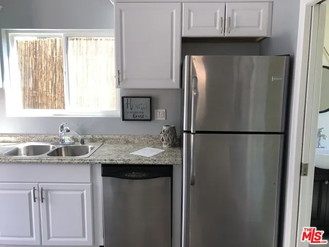 a kitchen with stainless steel appliances granite countertop a refrigerator sink and cabinets