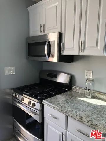 a kitchen with granite countertop a stove and a sink
