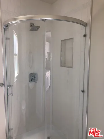 a bathroom with a shower and a mirror
