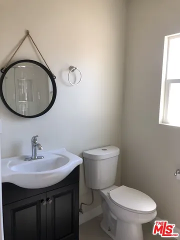a bathroom with a toilet a sink and mirror