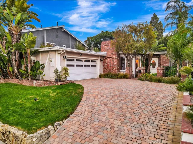 a front view of a house with a yard and potted plants