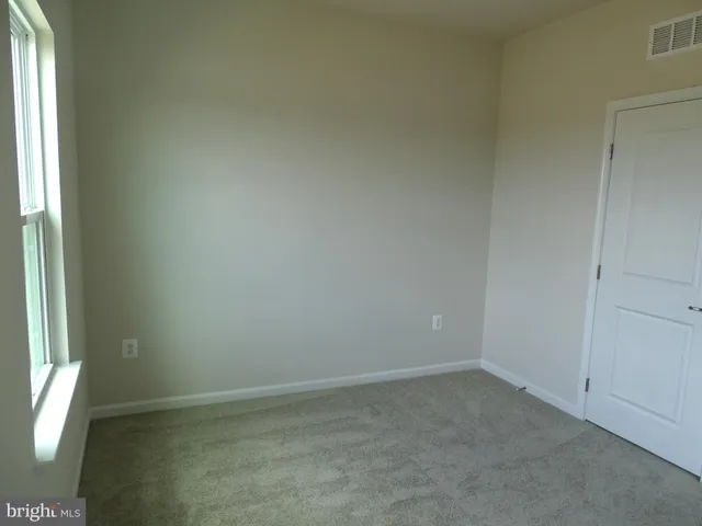 a view of an empty room with closet area