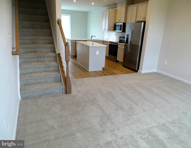 a kitchen with a refrigerator a stove top oven and cabinets
