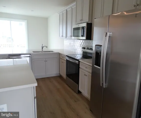 a kitchen with stainless steel appliances a refrigerator sink and microwave