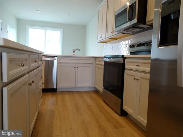 a kitchen with a sink a stove and cabinets