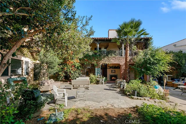 a view of a patio with table and chairs and potted plants with large tree