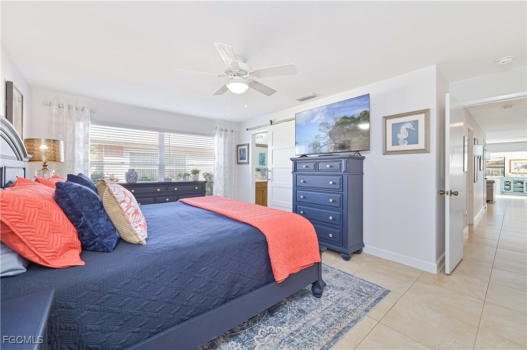 5590 Buring Court Fort Myers, FL 33919 - Photo 31 of 38 a bedroom with a large bed and a chandelier