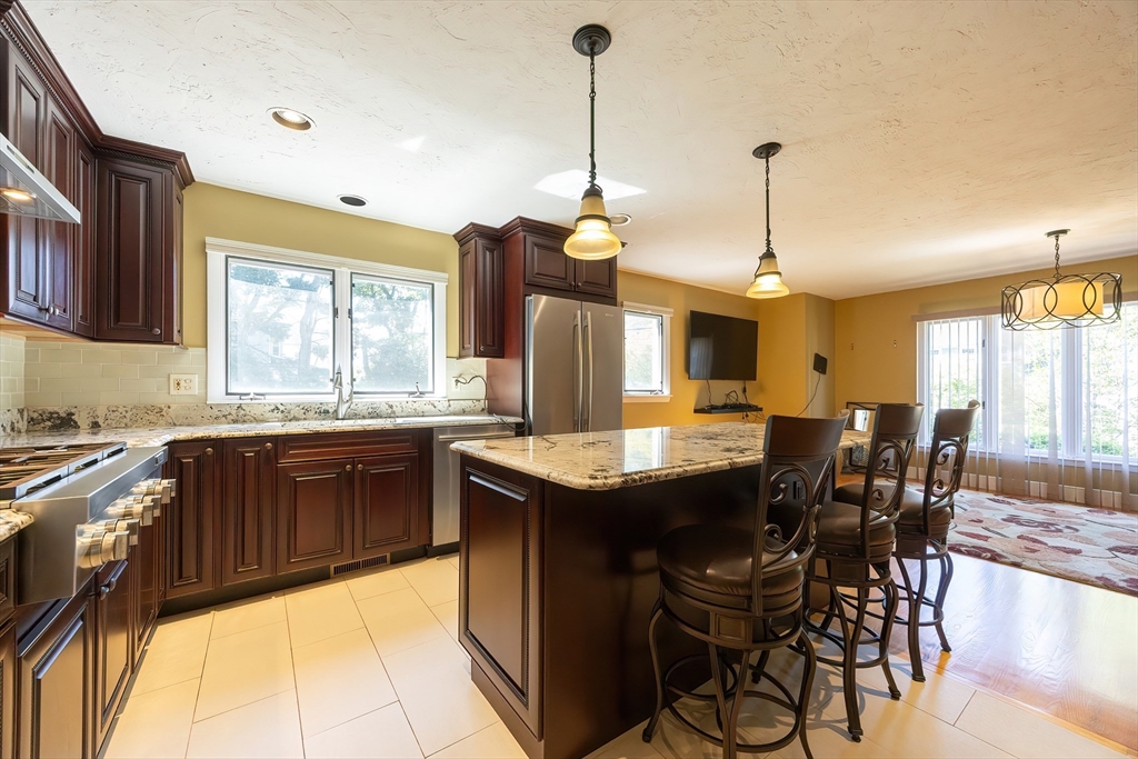 290 Central Avenue Milton, MA 02186 - Photo 14 of 40 a kitchen with stainless steel appliances granite countertop a stove a sink dishwasher and a wooden cabinets with large windows