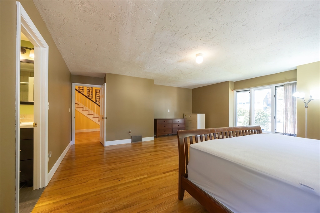 290 Central Avenue Milton, MA 02186 - Photo 20 of 40 a spacious bedroom with a bed and wooden floor