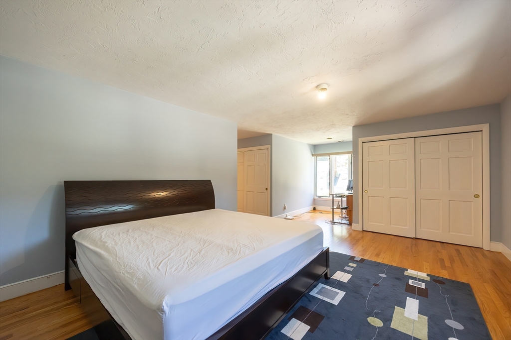 290 Central Avenue Milton, MA 02186 - Photo 30 of 40 a bedroom with a bed and wooden floor