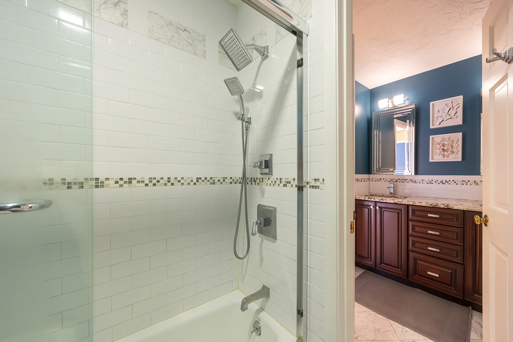 290 Central Avenue Milton, MA 02186 - Photo 33 of 40 a bathroom with a granite countertop sink a mirror and a bathtub