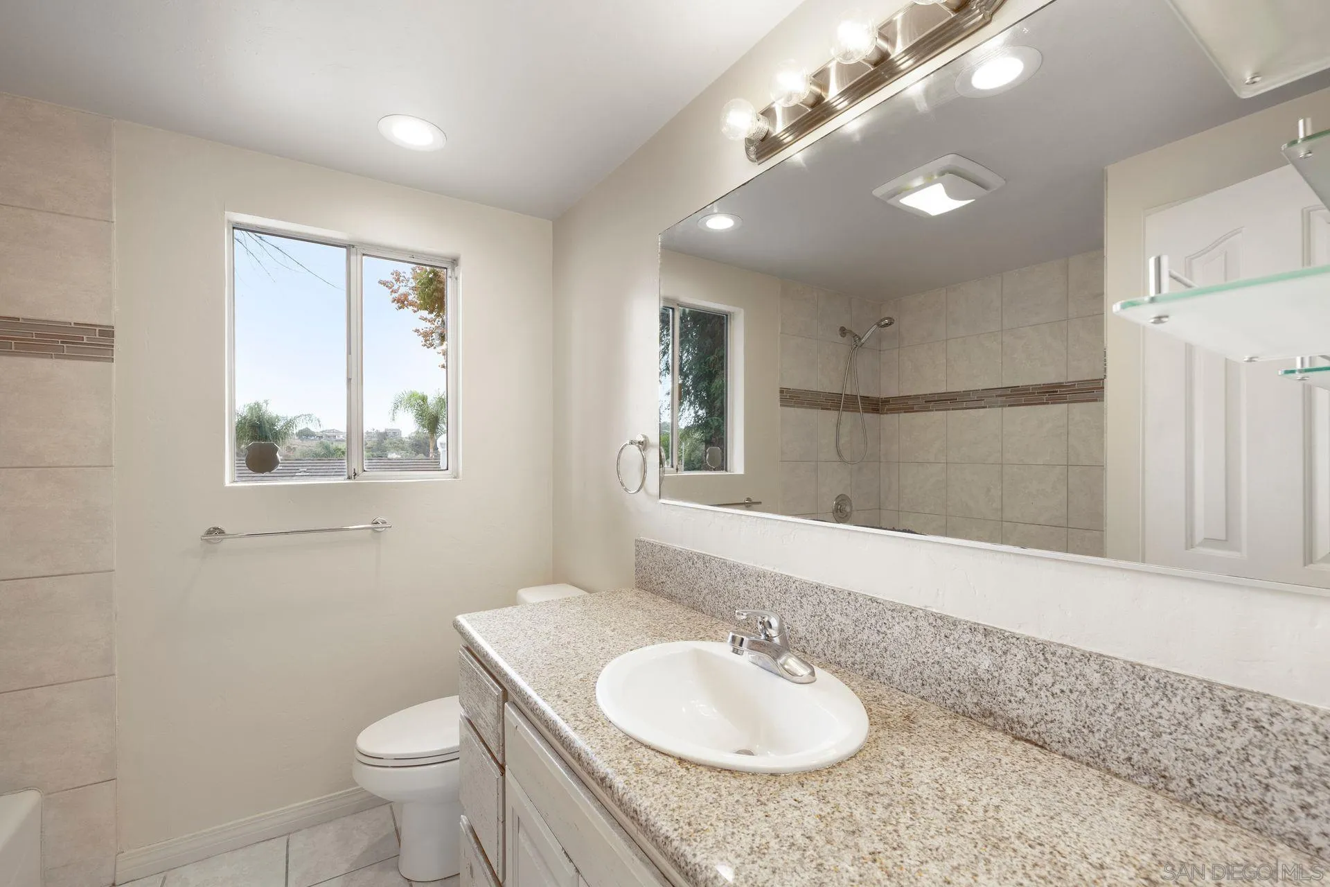 960 Sunset Drive Vista, CA 92081 - Photo 23 of 39 a bathroom with a granite countertop sink toilet and mirror