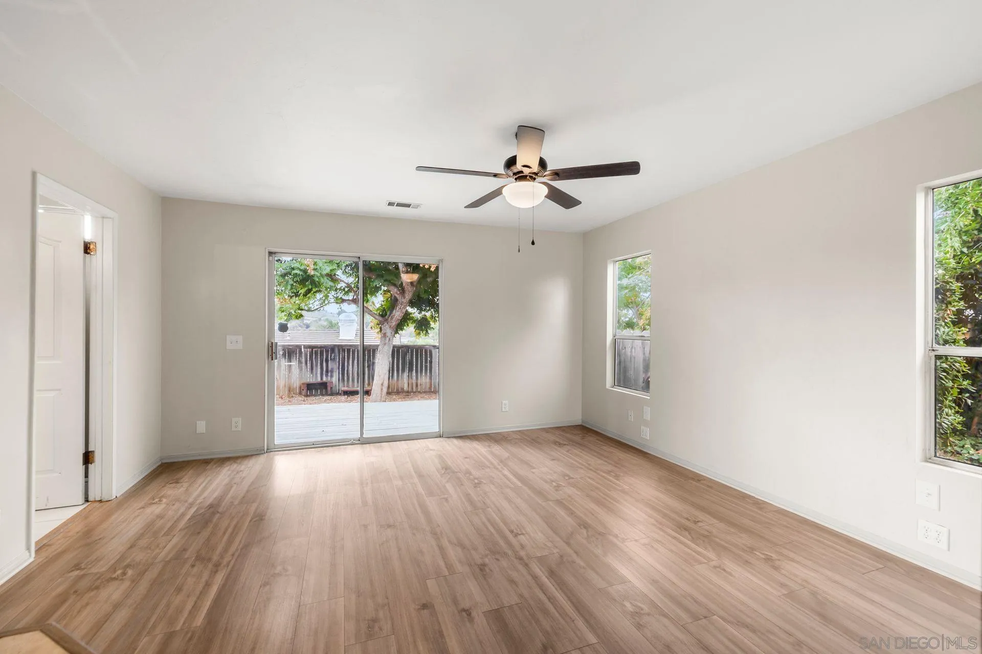 960 Sunset Drive Vista, CA 92081 - Photo 25 of 39 a view of an empty room with a window and wooden floor