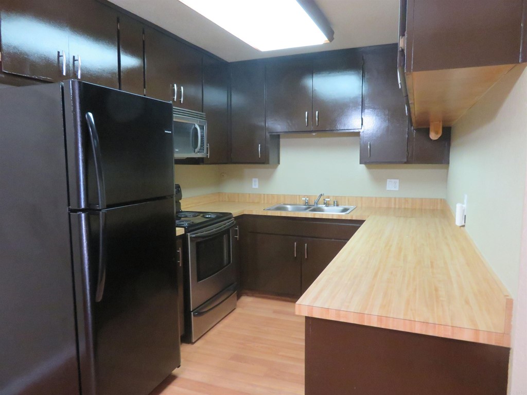620 Telegraph Canyon Road, Unit F Chula Vista, CA 91910 - Photo 1 of 1 a kitchen with a sink stainless steel appliances and refrigerator