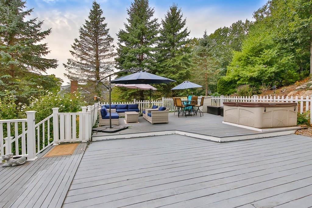 16 Boston Road Newbury, MA 01951 - Photo 28 of 30 a view of a patio with dining table and chairs under an umbrella with wooden floor and fence
