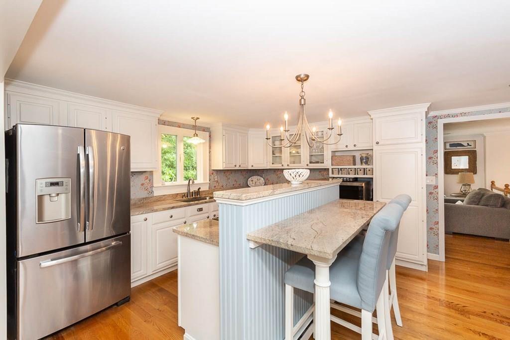 16 Boston Road Newbury, MA 01951 - Photo 8 of 30 a kitchen with granite countertop a refrigerator a stove a sink and white cabinets with wooden floor