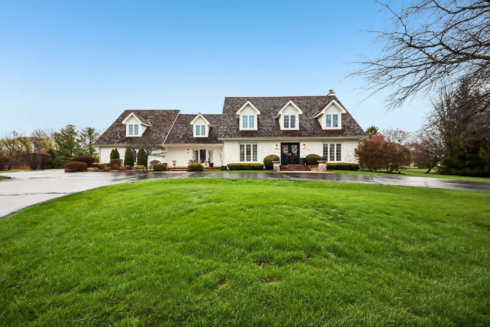 a front view of a house with a yard and trees