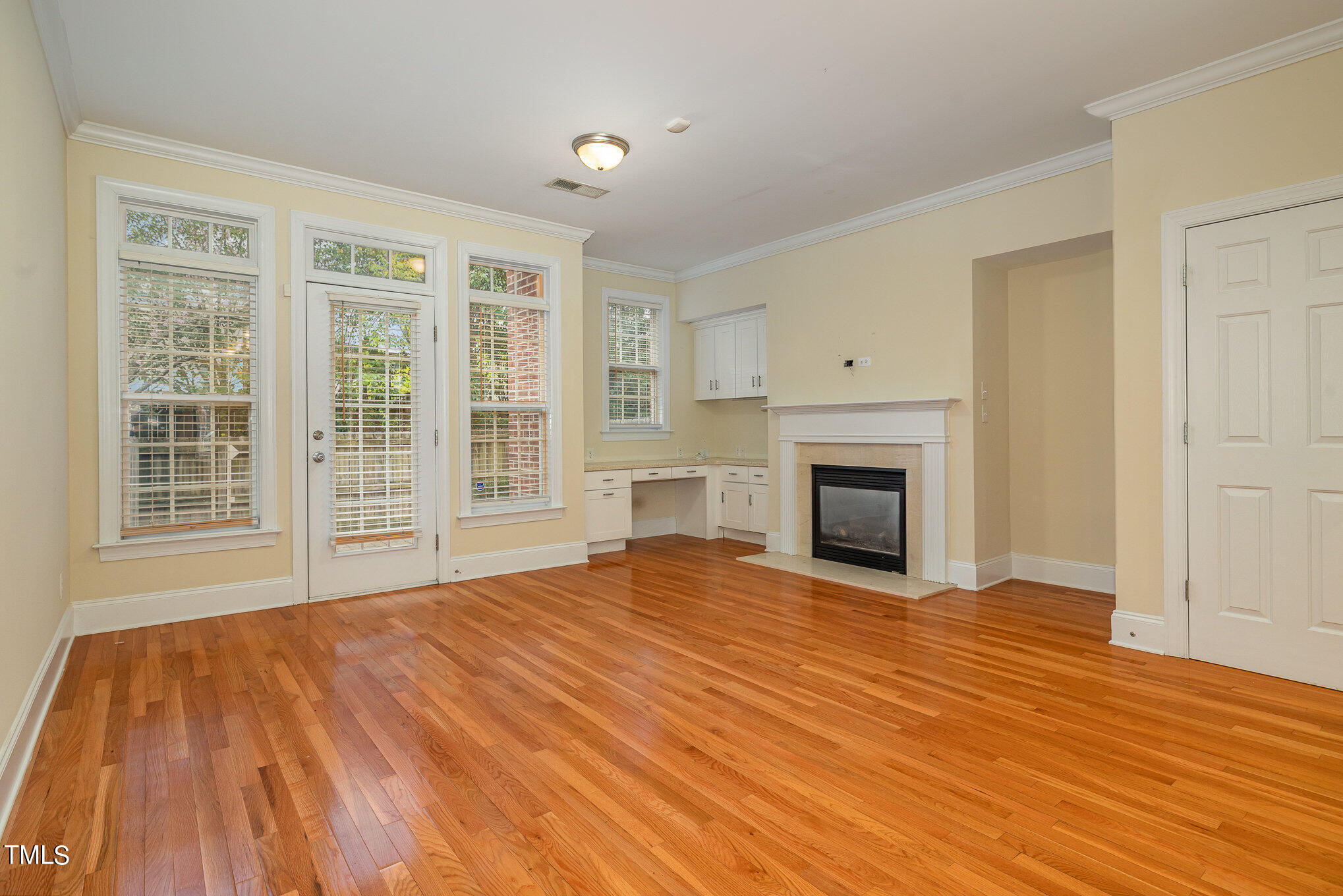 673 Highpark Lane Raleigh, NC 27608 - Photo 12 of 22 a view of an empty room with wooden floor fireplace and a window
