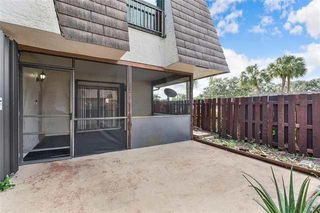 a view of a backyard with plants and wooden fence