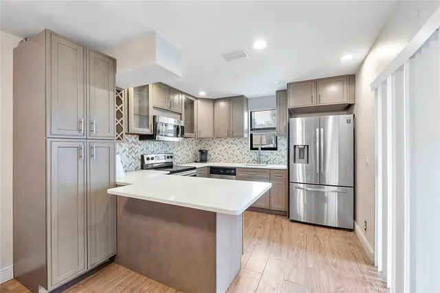 a kitchen with kitchen island a refrigerator sink and cabinets