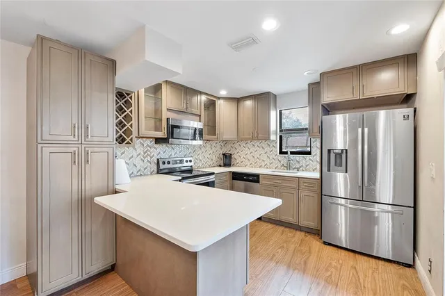 a kitchen with a refrigerator a stove top oven a sink and cabinets