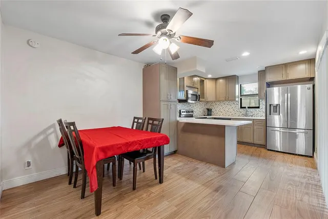 a kitchen with a sink a refrigerator and chairs