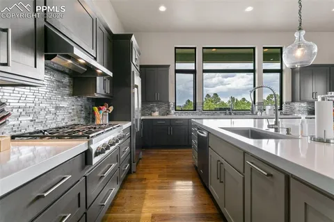 a kitchen with stainless steel appliances a sink stove and cabinets