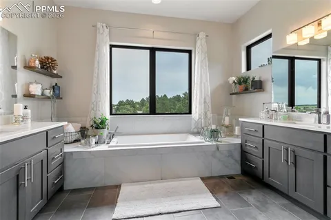 a bathroom with a bathtub a sink and a large mirror