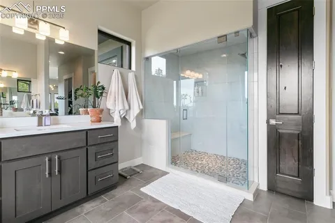 a bathroom with a sink a large mirror and a shower