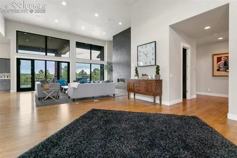 a living room with fireplace furniture and floor to ceiling window