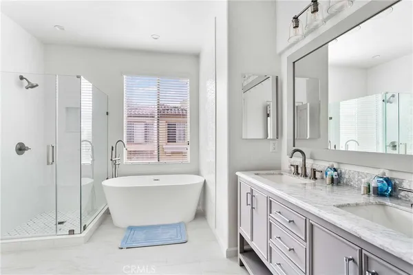 a spacious bathroom with a double vanity sink mirror and bathtub