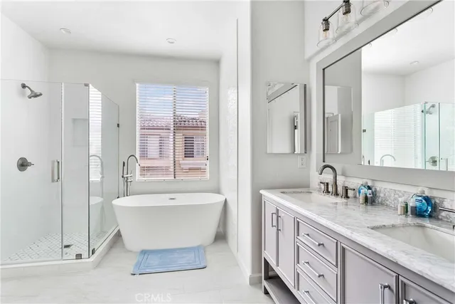 a spacious bathroom with a double vanity sink mirror and bathtub