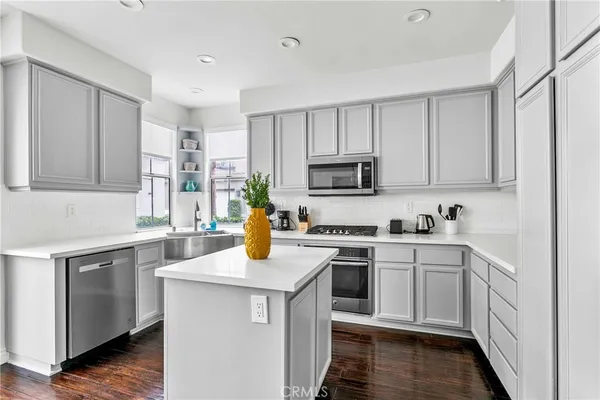 a kitchen with sink a microwave and cabinets