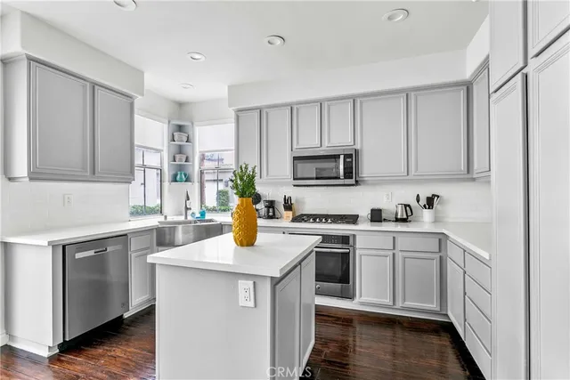 a kitchen with sink a microwave and cabinets