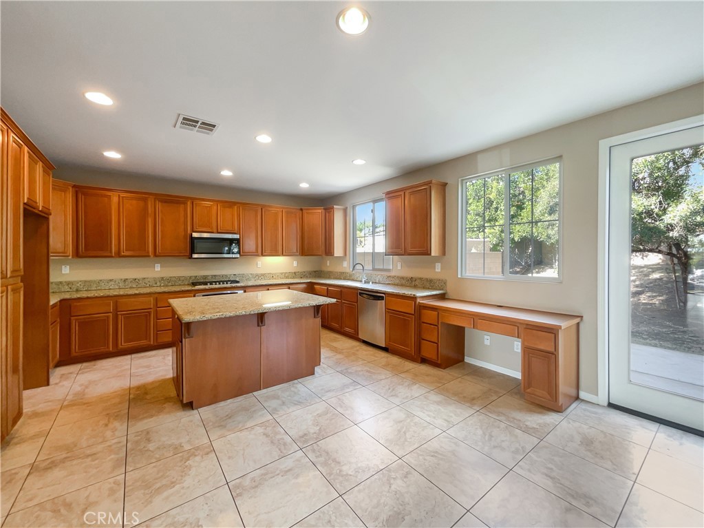 28872 Cedar Brook Lane Menifee, CA 92584 - Photo 11 of 26 a large kitchen with granite countertop a large counter top stainless steel appliances and cabinets